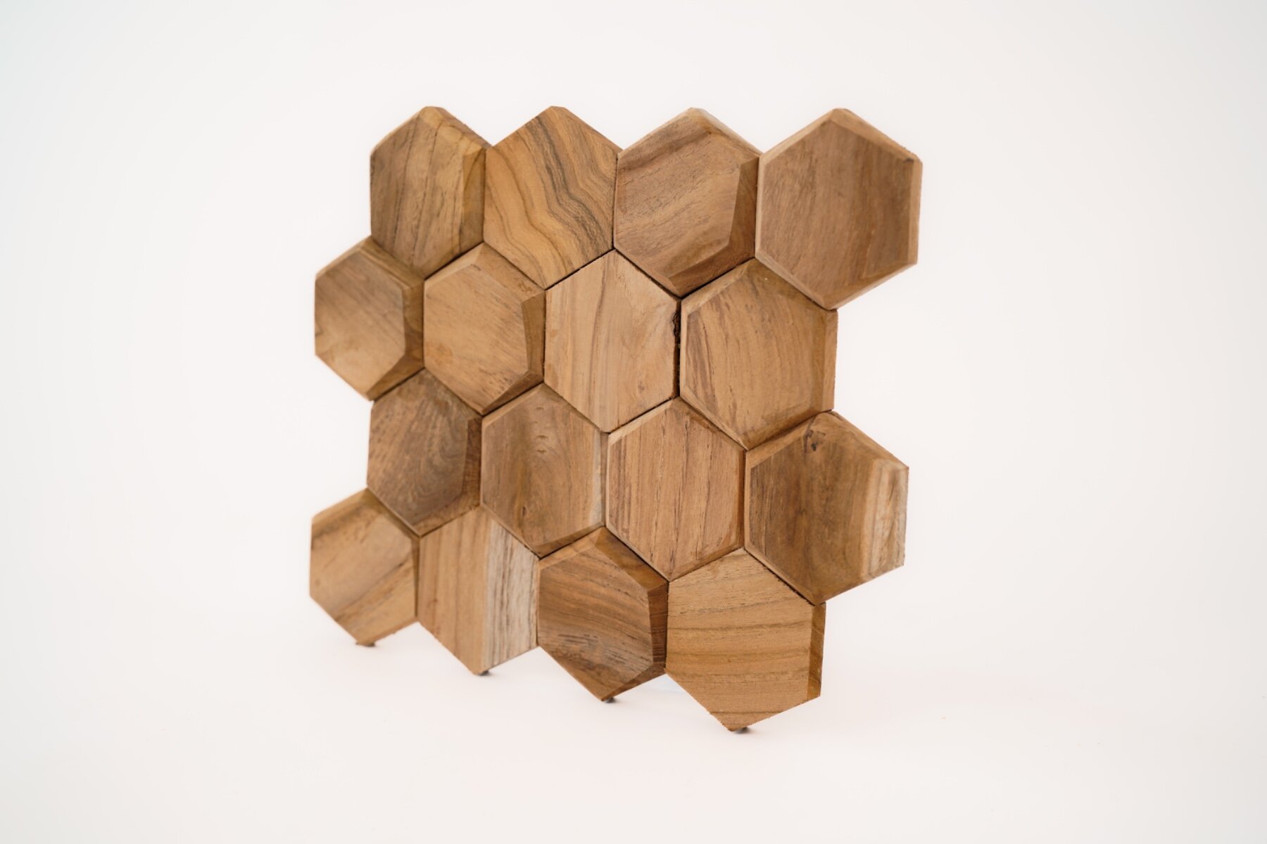 Teakea Hexagon wandpanelen van duurzaam teakhout, zeshoekige vorm, gemonteerd op een muur voor een moderne en natuurlijke uitstraling in het interieur.