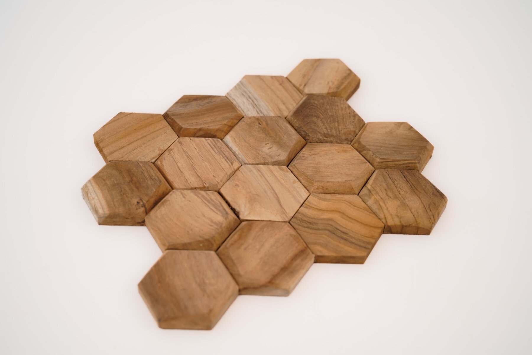Teakea Hexagon wandpanelen van duurzaam teakhout, zeshoekige vorm, gemonteerd op een muur voor een moderne en natuurlijke uitstraling in het interieur.