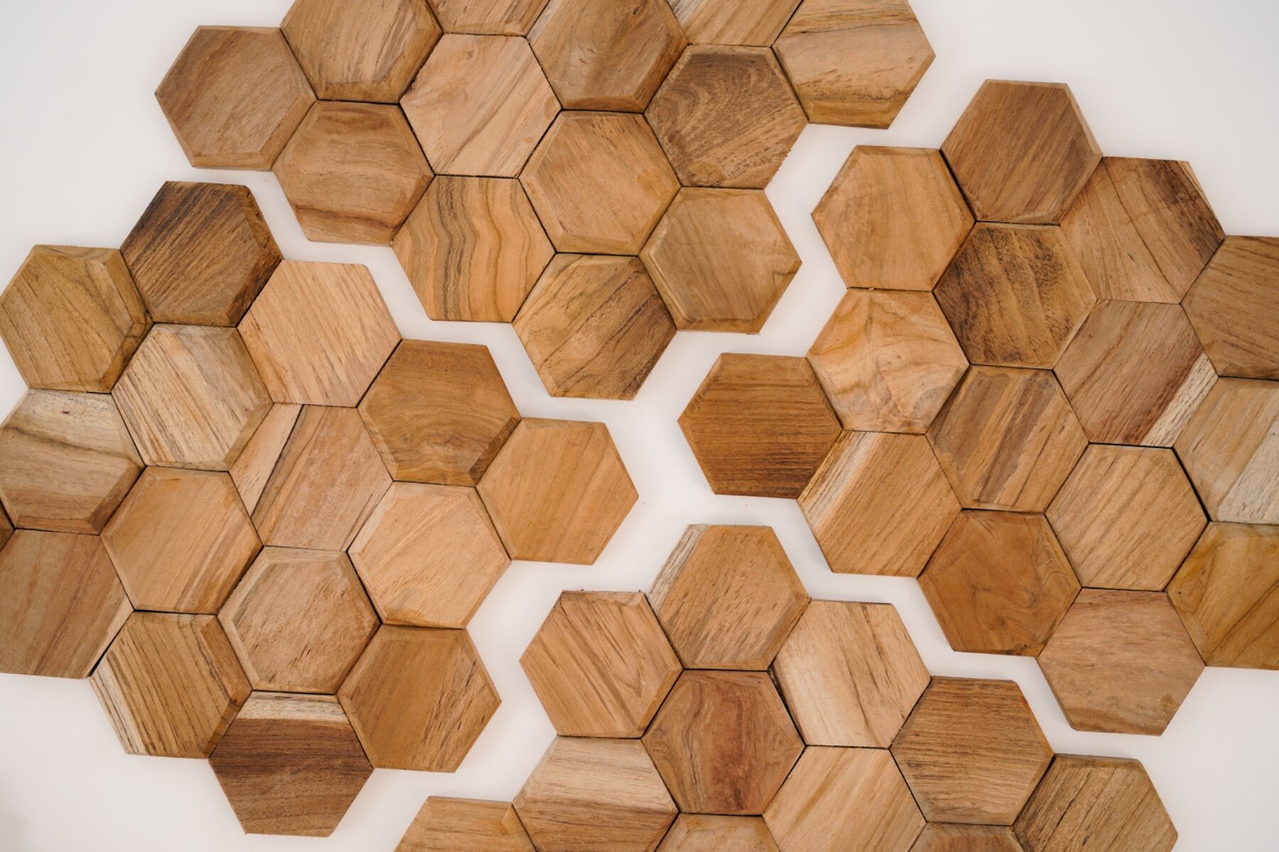 Teakea Hexagon wandpanelen van duurzaam teakhout, zeshoekige vorm, gemonteerd op een muur voor een moderne en natuurlijke uitstraling in het interieur.