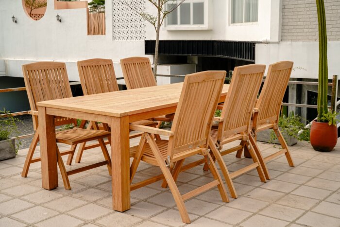 Teakhouten Nelson tuintafel 220x100 met 6 verstelbare Linda stoelen, luxe buitenmeubelset op een terras.