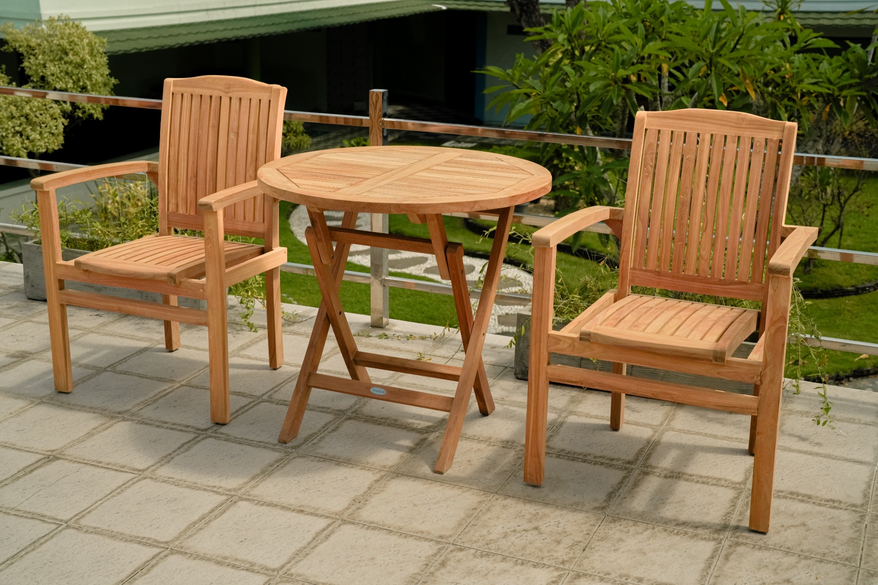 Twee teakhouten, stapelbare Ibiza tuinstoelen staan naast een vierkante, deels ingeklapte teakhouten tuintafel op een zonnig terras.
 - Hover