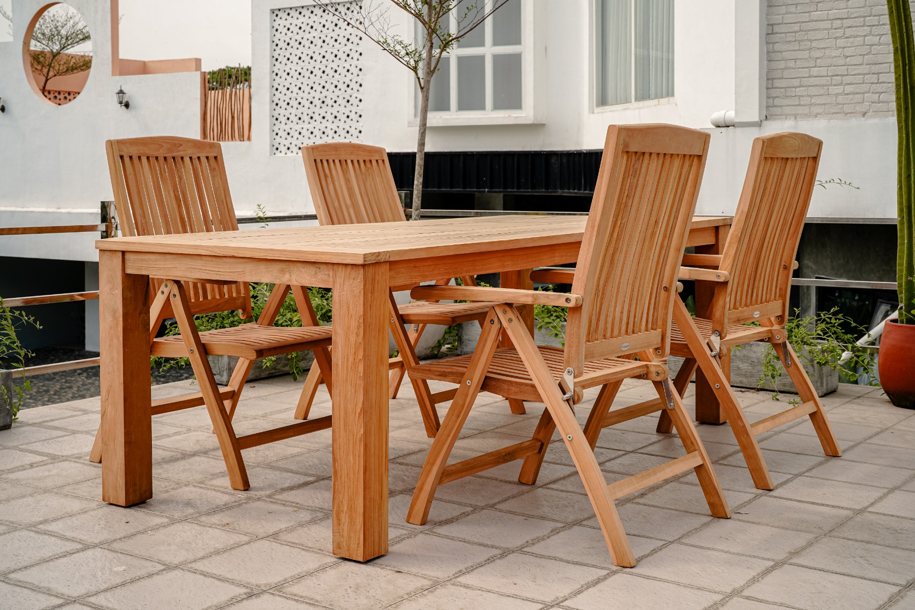 Teakhouten Nelson tuintafel 160x90 met 4 verstelbare Linda stoelen, buitenmeubelset op een terras. - Hover