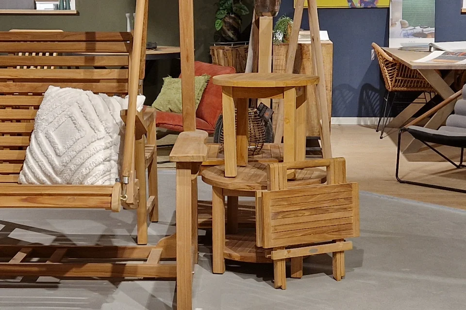 Kleine houten tuintafels bij een tuinmeubelopstelling in de showroom